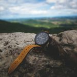 round black analog watch on stone