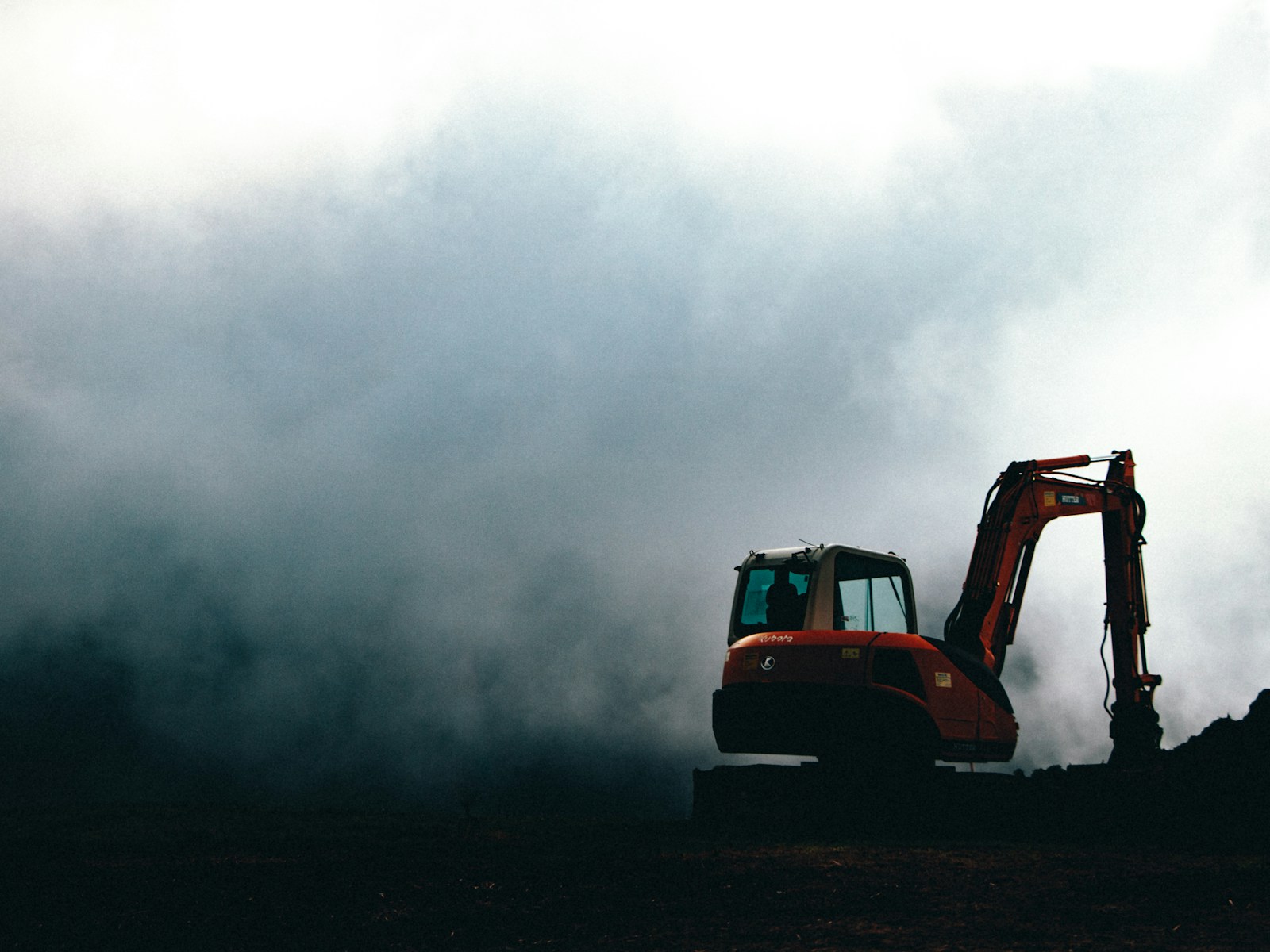 a bulldozer in the middle of a field on a cloudy day