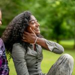 Two smiling women in a park
